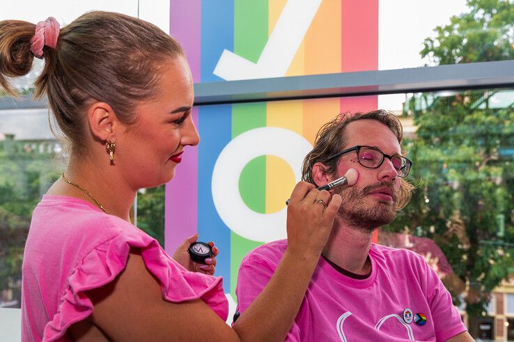 Ayla Klein Gunnewiek bezig met de make-up van een bezoeker van Zwolle Pride. - Foto: Peter Denekamp