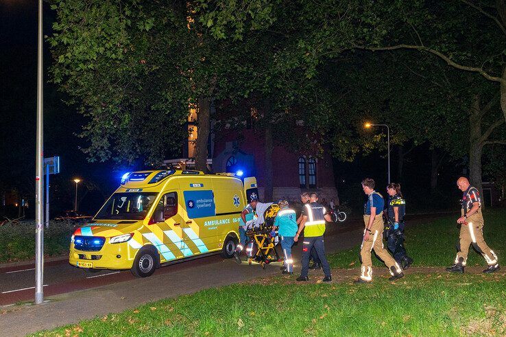 Hulpverleners brengen de verwarde man naar de gereedstaande ambulance. - Foto: Peter Denekamp