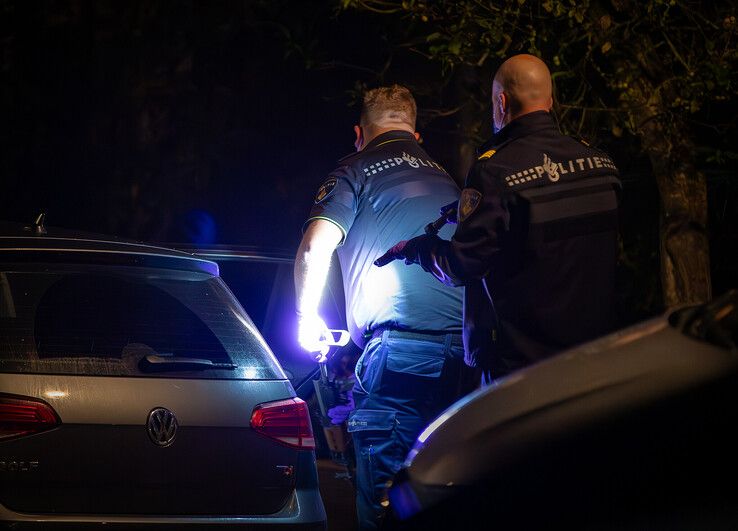 Een politieman haalt het automatische vuurwapen uit de auto op de Arne. - Foto: Hugo Janssen