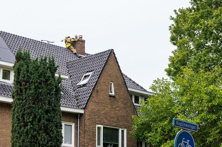 In beeld: Brandweer heeft grote moeite om bij schoorsteenbrand te komen in Zwolle - Foto: Peter Denekamp