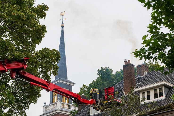 Brandweerlieden bestrijden de schoorsteenbrand aan de Bagijnesingel. - Foto: Peter Denekamp