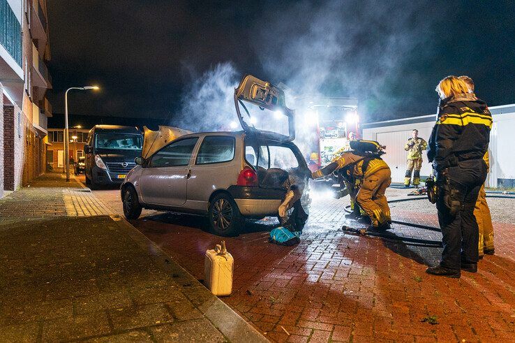 De in brand gestoken auto op een parkeerplaats achter een flat aan de Lassuslaan. - Foto: Peter Denekamp