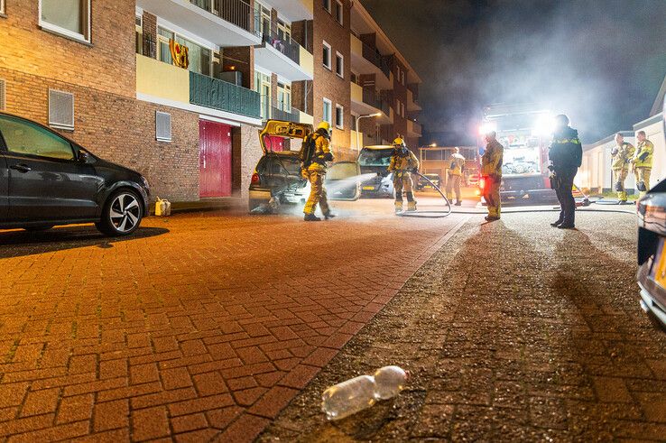 Nabij de brandende auto lag een lege frisdrankfles. - Foto: Peter Denekamp