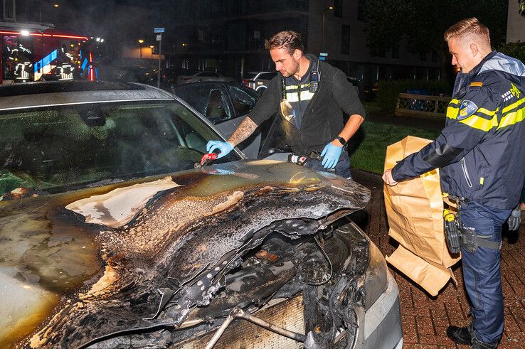 Een politieman stelt sporen van brandstichting veilig. - Foto: Peter Denekamp