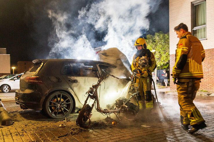 Een auto en scooter werden door brand verwoest op de Von Weberhof. - Foto: Peter Denekamp