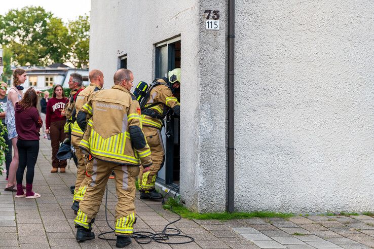 Een brandweerman gaat de studentenwoning binnen na de brandmelding. - Foto: Peter Denekamp