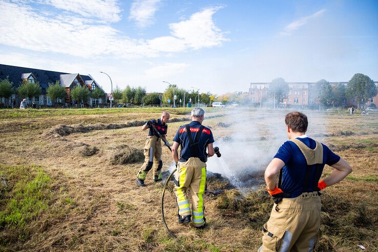 De brandweer blust de strook gras in Stadshagen. - Foto: Hugo Janssen