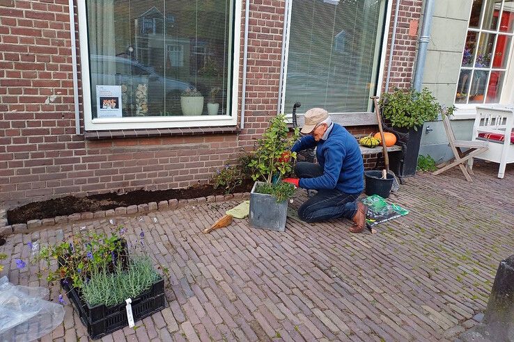 Een bewoner bezig met de aanleg van een geveltuintje. - Foto: Gemeente Zwartewaterland