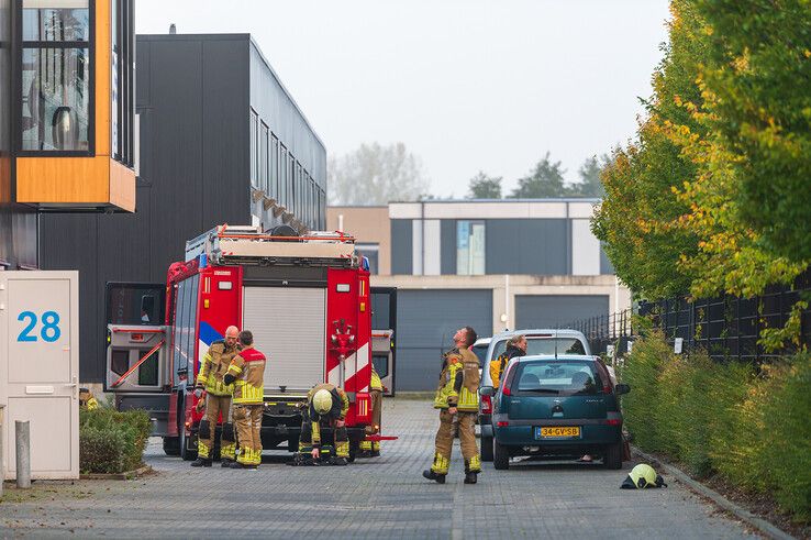 Brandweerlieden verdrijven de rooklucht uit het kantoor aan de Eiffelstraat. - Foto: Peter Denekamp