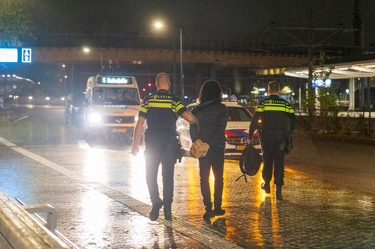 Een verdachte van de overval in Hattem wordt afgevoerd door politieagenten. - Foto: Peter Denekamp