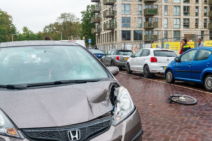 De zwaarbeschadigde auto en de in stukken gebroken fiets op de Schuurmanstraat. - Foto: Peter Denekamp