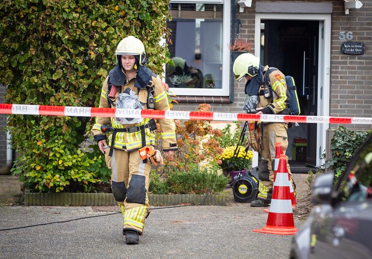 Brandweerlieden zogen met een afzuiger het gas onder de woning weg. - Foto: Hugo Janssen