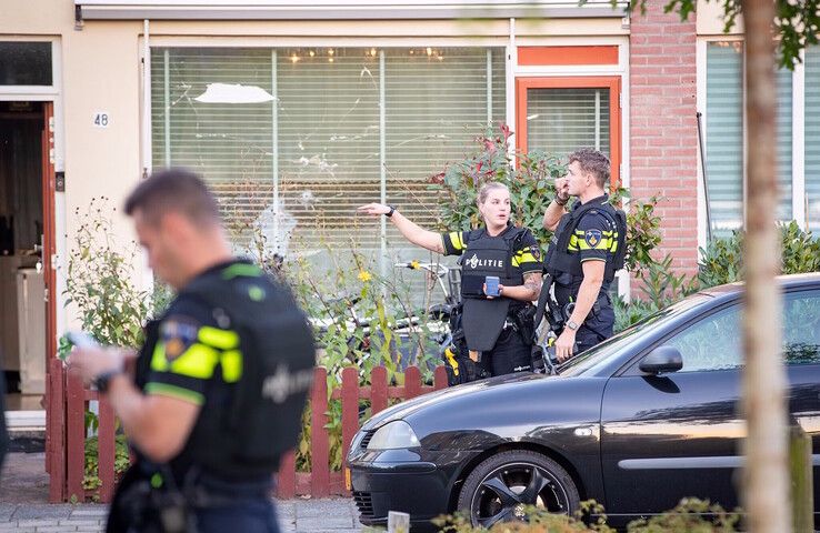 Politieagenten voor de beschoten woning aan de Schubertstraat. - Foto: Hugo Janssen