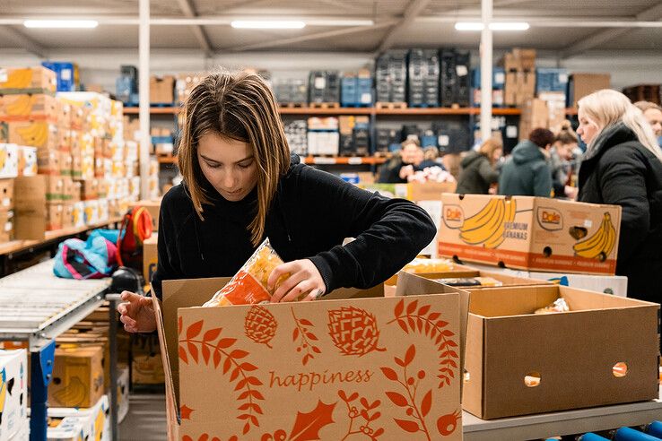 Een vrijwilliger pakt een kerstpakket in tijdens een eerdere actie. - Foto: Peter van der Lingen