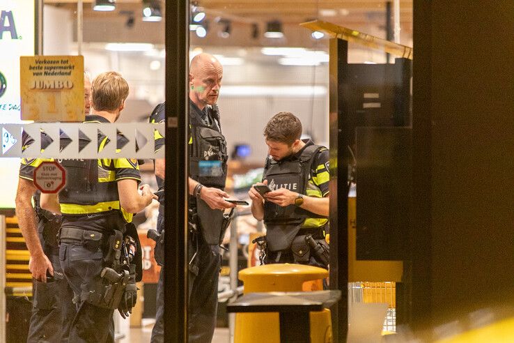 Politieagenten in kogelwerende vesten in de Jumbo-supermarkt in Stadshagen. - Foto: Ruben Meinten