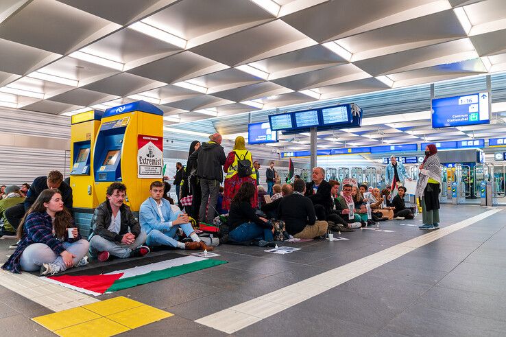 De pro-Palestijnse demonstranten zitten op de grond in de reizigerstunnel van station Zwolle. - Foto: Peter Denekamp