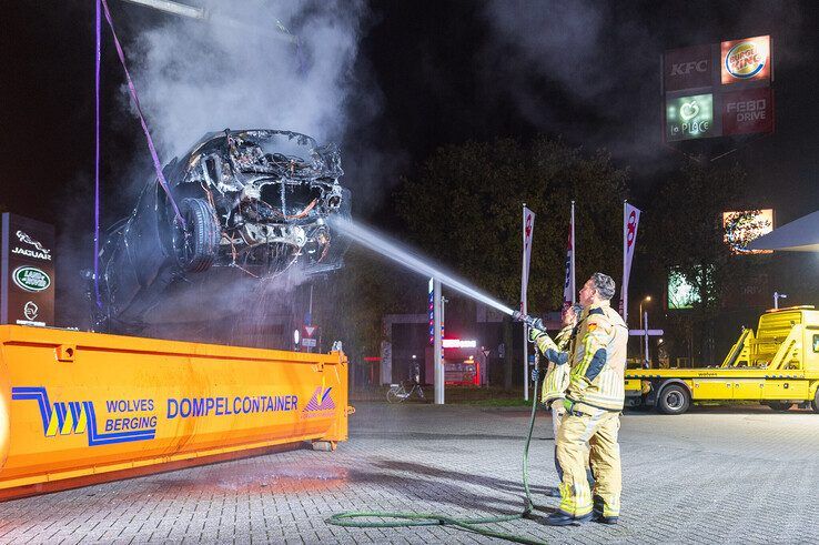 In beeld: Elektrische auto aan laadpaal vliegt in brand in Zwolle, brandweer urenlang in touw - Foto: Peter Denekamp