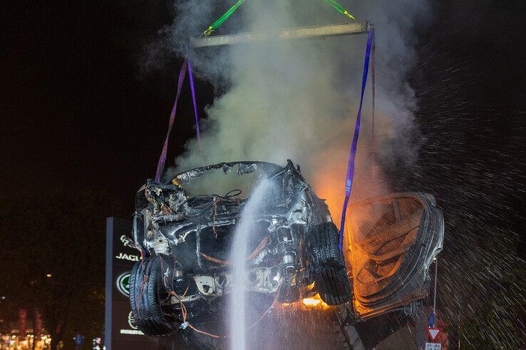 In beeld: Elektrische auto aan laadpaal vliegt in brand in Zwolle, brandweer urenlang in touw - Foto: Peter Denekamp