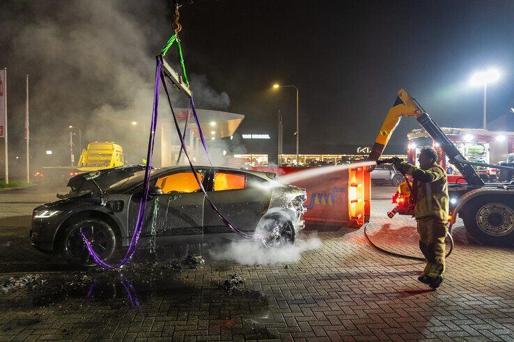 In beeld: Elektrische auto aan laadpaal vliegt in brand in Zwolle, brandweer urenlang in touw - Foto: Peter Denekamp