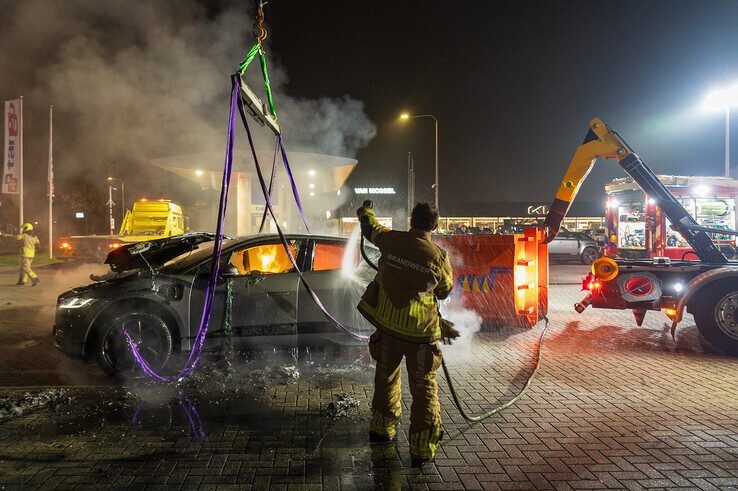 In beeld: Elektrische auto aan laadpaal vliegt in brand in Zwolle, brandweer urenlang in touw - Foto: Peter Denekamp