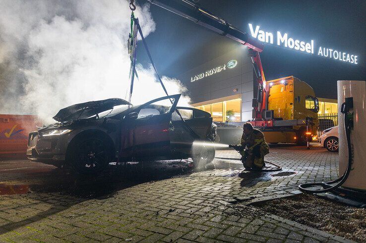 In beeld: Elektrische auto aan laadpaal vliegt in brand in Zwolle, brandweer urenlang in touw - Foto: Peter Denekamp