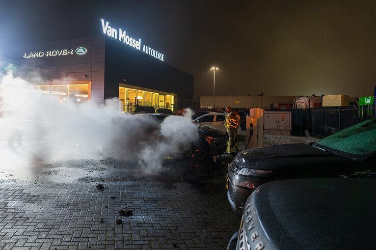 In beeld: Elektrische auto aan laadpaal vliegt in brand in Zwolle, brandweer urenlang in touw - Foto: Peter Denekamp