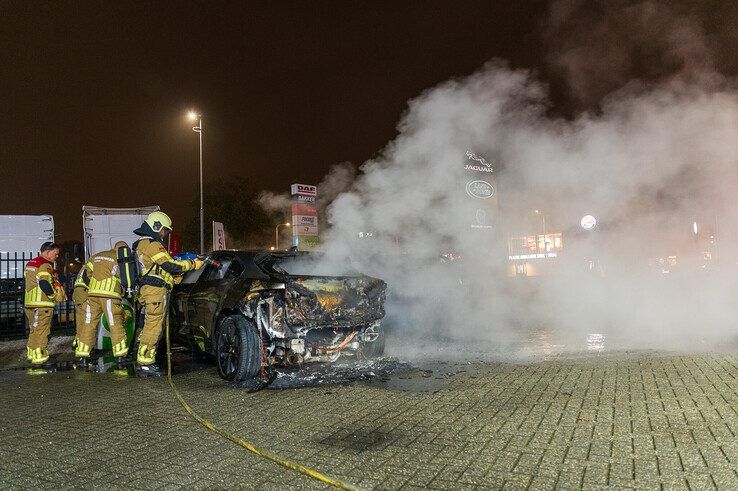 In beeld: Elektrische auto aan laadpaal vliegt in brand in Zwolle, brandweer urenlang in touw - Foto: Peter Denekamp