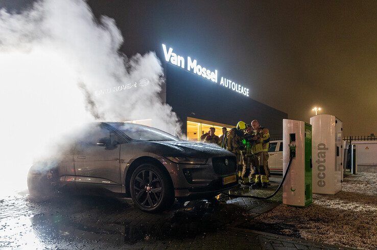 In beeld: Elektrische auto aan laadpaal vliegt in brand in Zwolle, brandweer urenlang in touw - Foto: Peter Denekamp