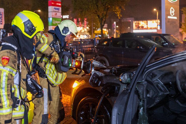 In beeld: Elektrische auto aan laadpaal vliegt in brand in Zwolle, brandweer urenlang in touw - Foto: Peter Denekamp