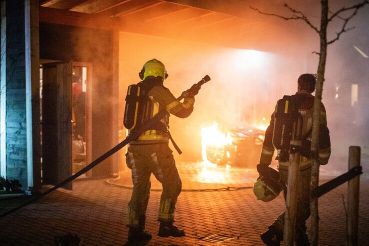 De auto staat in lichterlaaie onder de carport. - Foto: Hugo Janssen