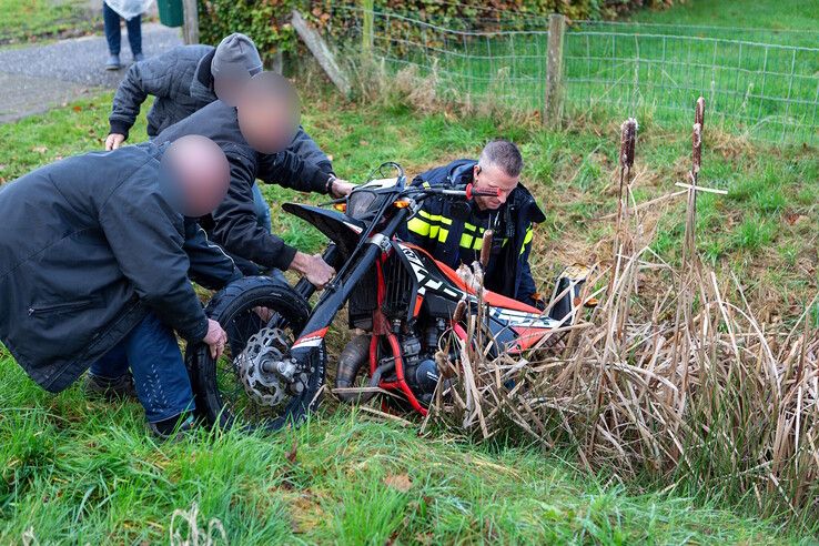 De bromfiets wordt uit de sloot gevist. - Foto: Ruben Meinten