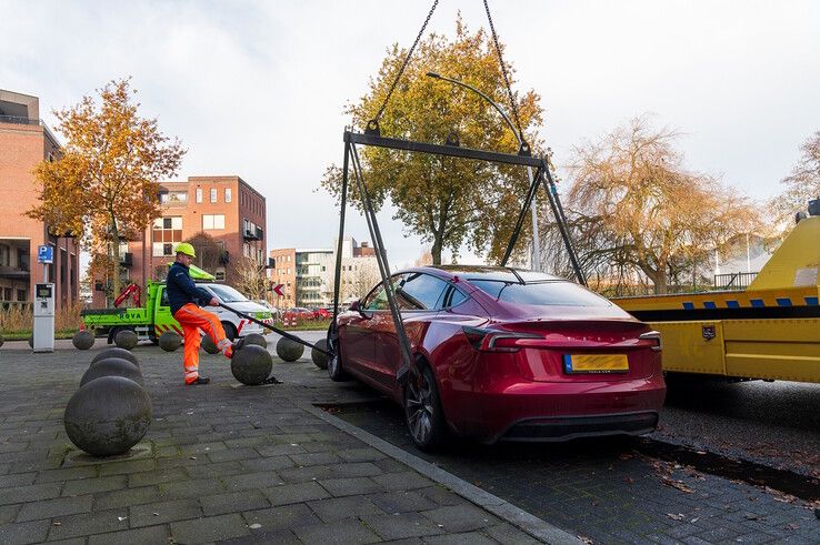 In beeld: Achterwaarts inparkeren op Hanzelaan gaat fout, Tesla muurvast op betonnen bol - Foto: Peter Denekamp