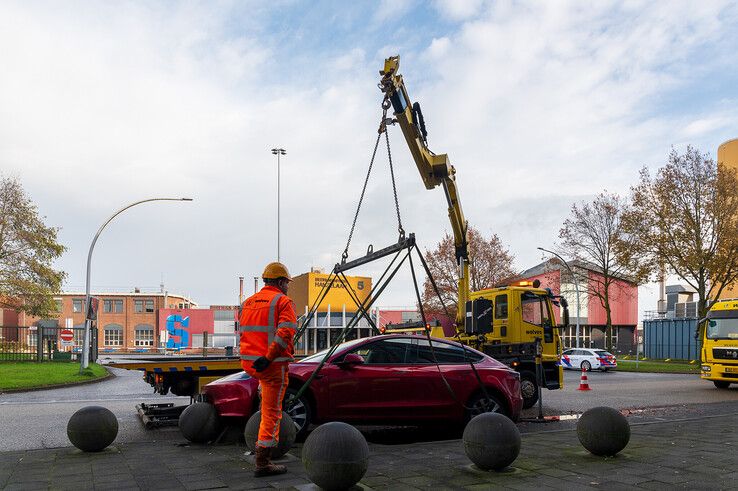 In beeld: Achterwaarts inparkeren op Hanzelaan gaat fout, Tesla muurvast op betonnen bol - Foto: Peter Denekamp