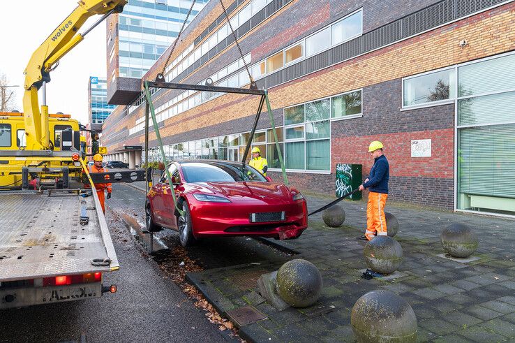 In beeld: Achterwaarts inparkeren op Hanzelaan gaat fout, Tesla muurvast op betonnen bol - Foto: Peter Denekamp