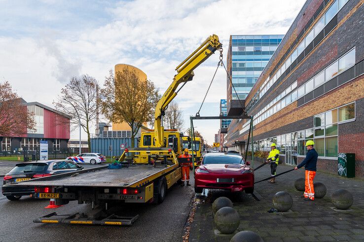 In beeld: Achterwaarts inparkeren op Hanzelaan gaat fout, Tesla muurvast op betonnen bol - Foto: Peter Denekamp