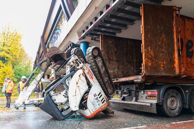 De graafmachine viel uit de container, een fietsster raakte lichtgewond. - Foto: Peter Denekamp