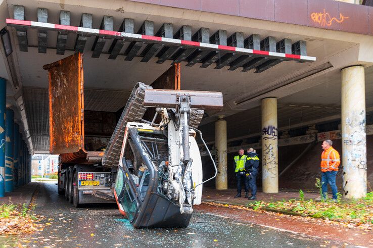 In beeld: Graafmachine valt uit vrachtwagen in Holtenbroek, fietsster lichtgewond - Foto: Peter Denekamp