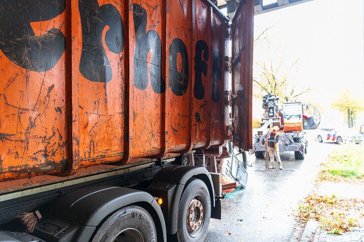 In beeld: Graafmachine valt uit vrachtwagen in Holtenbroek, fietsster lichtgewond - Foto: Peter Denekamp