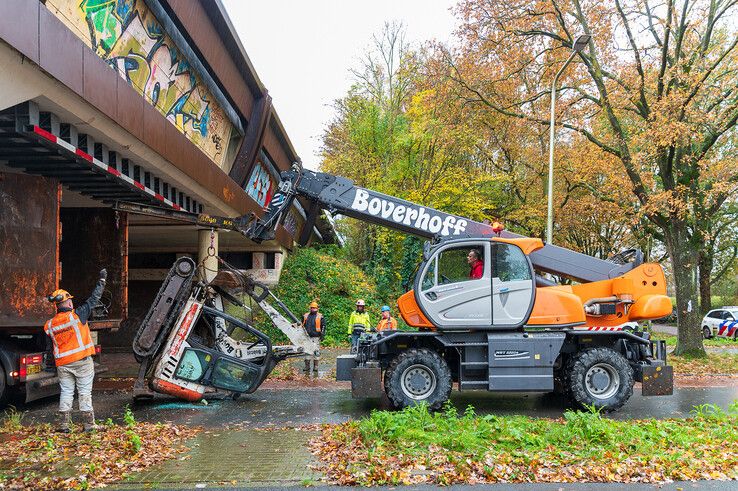 In beeld: Graafmachine valt uit vrachtwagen in Holtenbroek, fietsster lichtgewond - Foto: Peter Denekamp