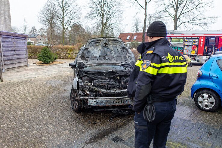 Een politieman bekijkt de uitgebrande auto. - Foto: Ruben Meinten