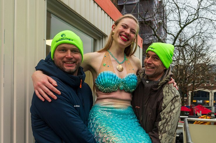 Duikers tillen een zeemeermin naar het water. - Foto: Peter Denekamp