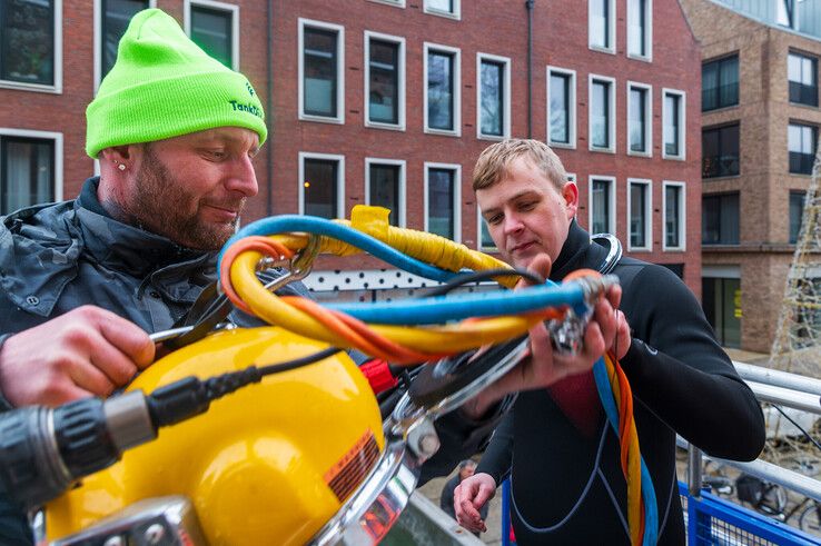 Beroepsduiker Appie geeft Patrick uitleg over de duikhelm. - Foto: Peter Denekamp