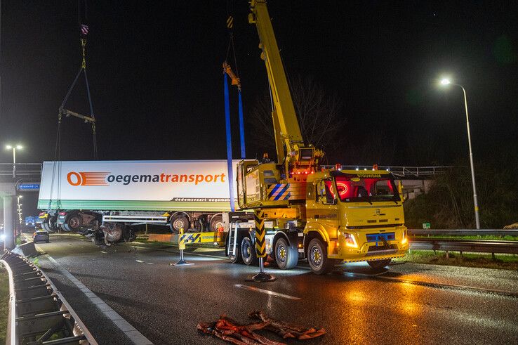 In beeld: Vrachtwagen schaart op A28 en knalt door vangrail, chauffeur gewond - Foto: Peter Denekamp