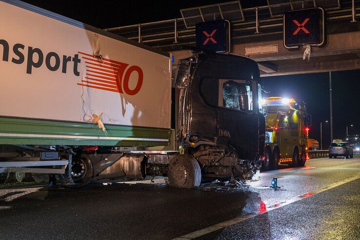 In beeld: Vrachtwagen schaart op A28 en knalt door vangrail, chauffeur gewond - Foto: Peter Denekamp