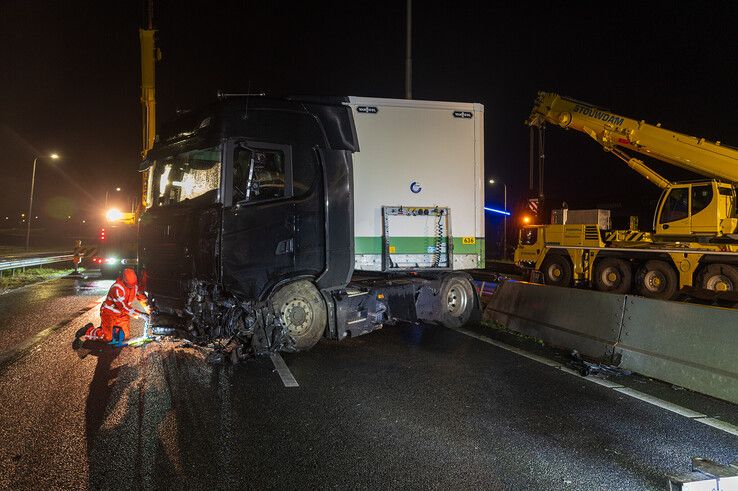 In beeld: Vrachtwagen schaart op A28 en knalt door vangrail, chauffeur gewond - Foto: Peter Denekamp