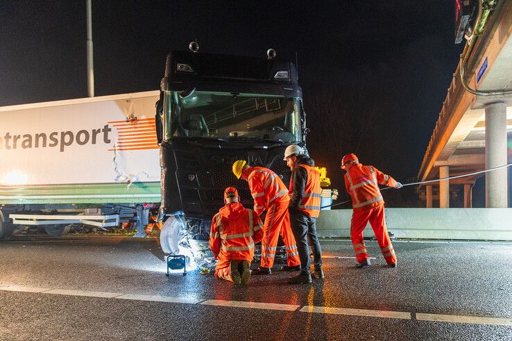 In beeld: Vrachtwagen schaart op A28 en knalt door vangrail, chauffeur gewond - Foto: Peter Denekamp