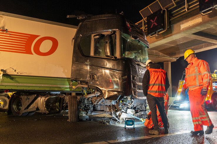 In beeld: Vrachtwagen schaart op A28 en knalt door vangrail, chauffeur gewond - Foto: Peter Denekamp