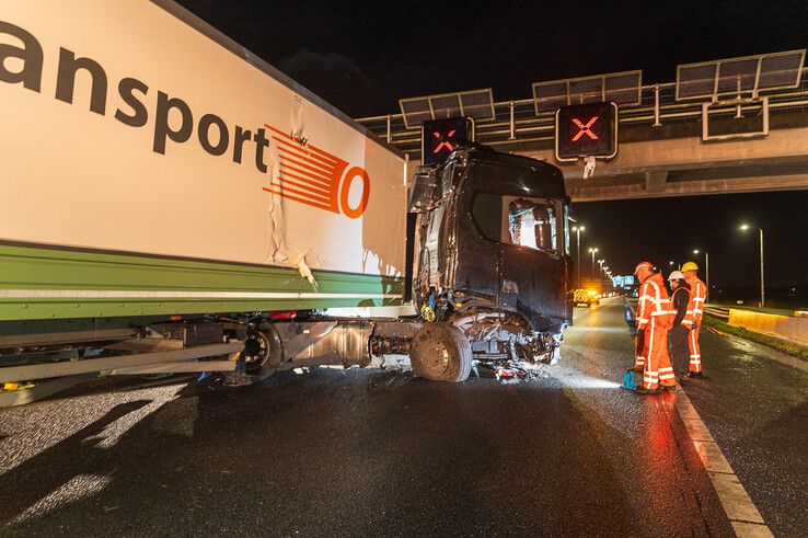 In beeld: Vrachtwagen schaart op A28 en knalt door vangrail, chauffeur gewond - Foto: Peter Denekamp