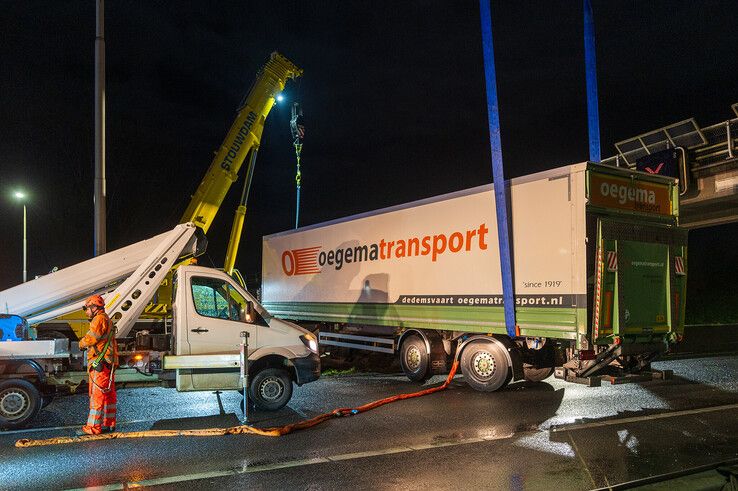 In beeld: Vrachtwagen schaart op A28 en knalt door vangrail, chauffeur gewond - Foto: Peter Denekamp