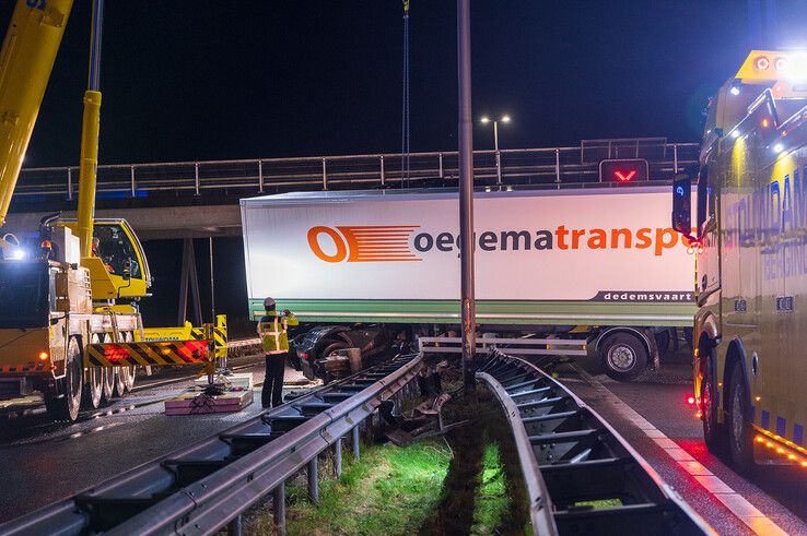 In beeld: Vrachtwagen schaart op A28 en knalt door vangrail, chauffeur gewond - Foto: Peter Denekamp